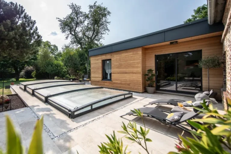 Flache Poolüberdachung neben einem modernen Haus mit Terrasse und Garten