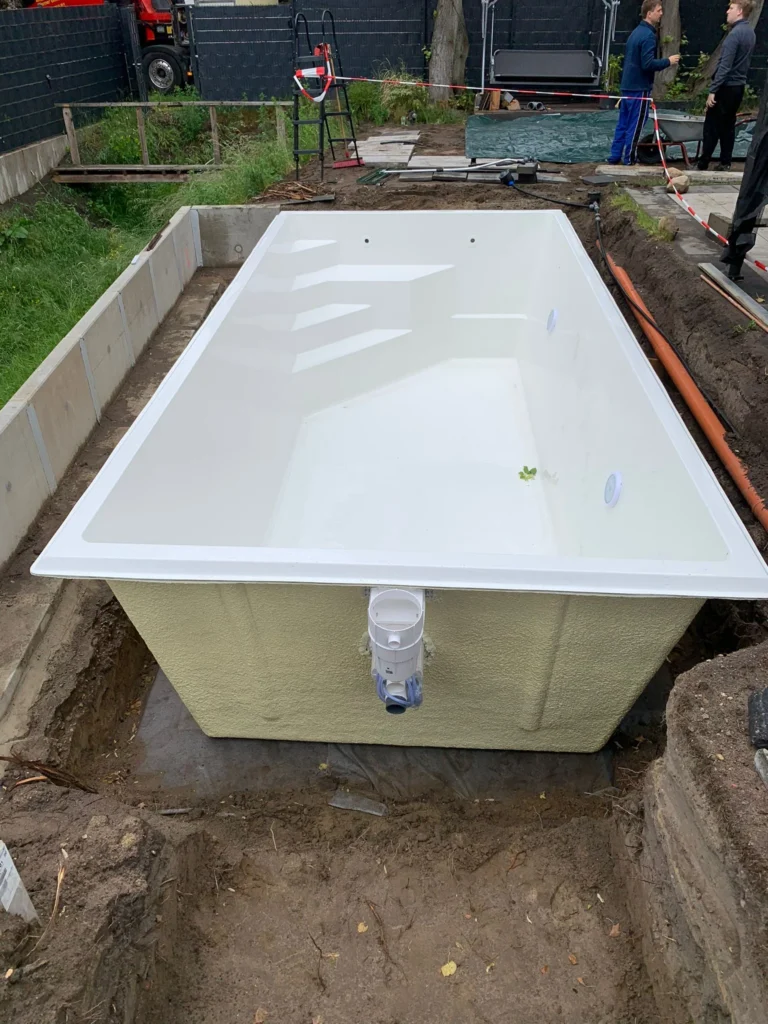 Weißer GFK-Pool während der Montagevorbereitung im Garten